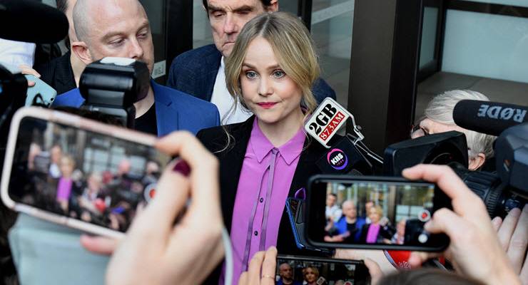eryn jean norvill outside court surrounded by media cameras and microphones