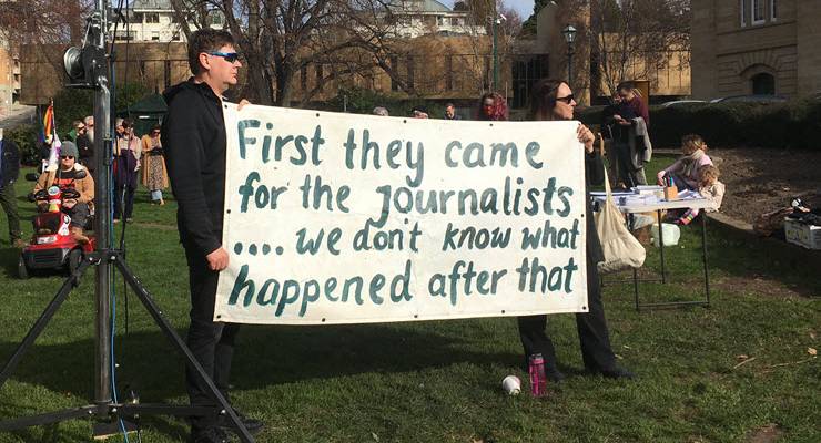 protesters with sign reading "first they came for the journalists -- we don't know what happened next"