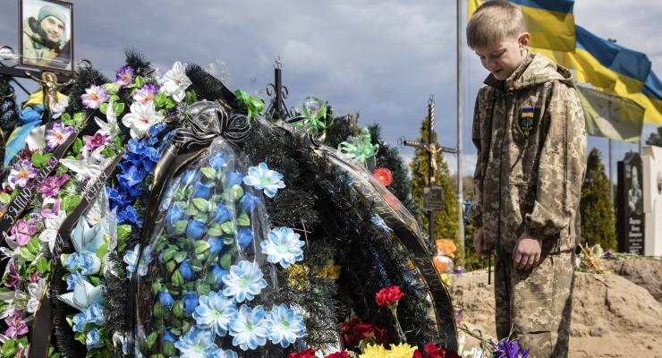 Ten-year-old Savelii at his father's grave in Irpin, Ukraine, 01 May 2022 (Image: EPA/Mikhail Palinchak)
