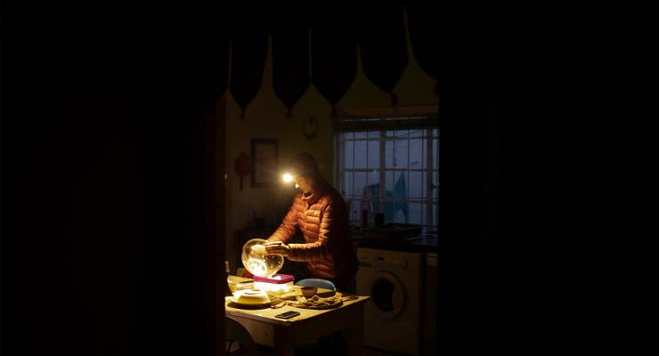 A woman in Johannesburg, South Africa, cooking dinner on a gas cylinder after another power cut (Image: AAP/EPA/KIM LUDBROOK)