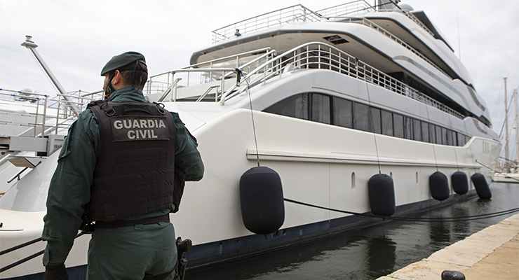 A guard stands by during a search of a yacht linked with Russian oligarch Viktor Vekselberg, a billionaire and close ally with Russia's President Vladimir Putin (Image: AAP/AP/Francisco Ubilla)
