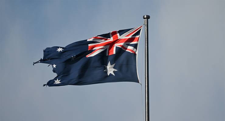 A tattered Australian flag on top of the Australian Parliament House (Image: AAP/Lukas Coch)
