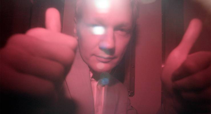 WikiLeaks founder Julian Assange behind a heavily tinted window of a police van, 2010 (Image: AAP/Akira Suemori)