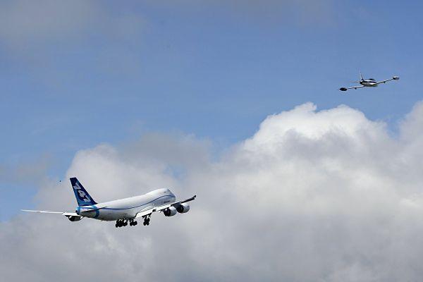 The 747-8F and chase jet head for clearer skies, AP photo