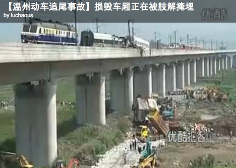 Consecutive extracts from a China media newscast, showing the general scene and at the foot of the viaduct at a pit being filled with the wreckge, victim retrieval